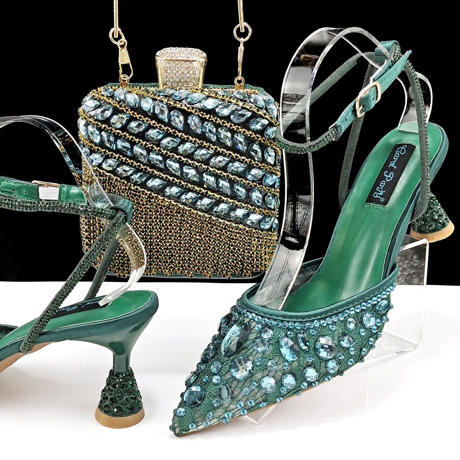 A set of green crystal-embellished slingback heels and a matching structured clutch with gold fringe and rhinestone detail.