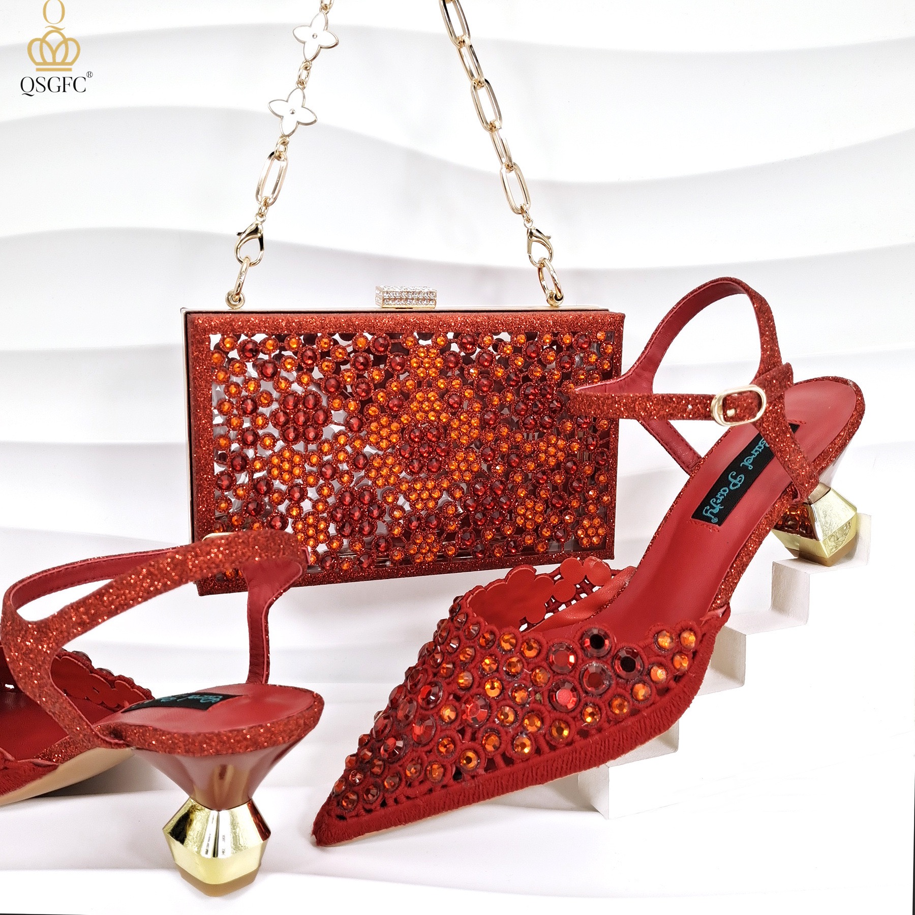 A pair of orange-red slingback heels with crystal embellishments and a matching rhinestone box clutch with a gold chain strap.